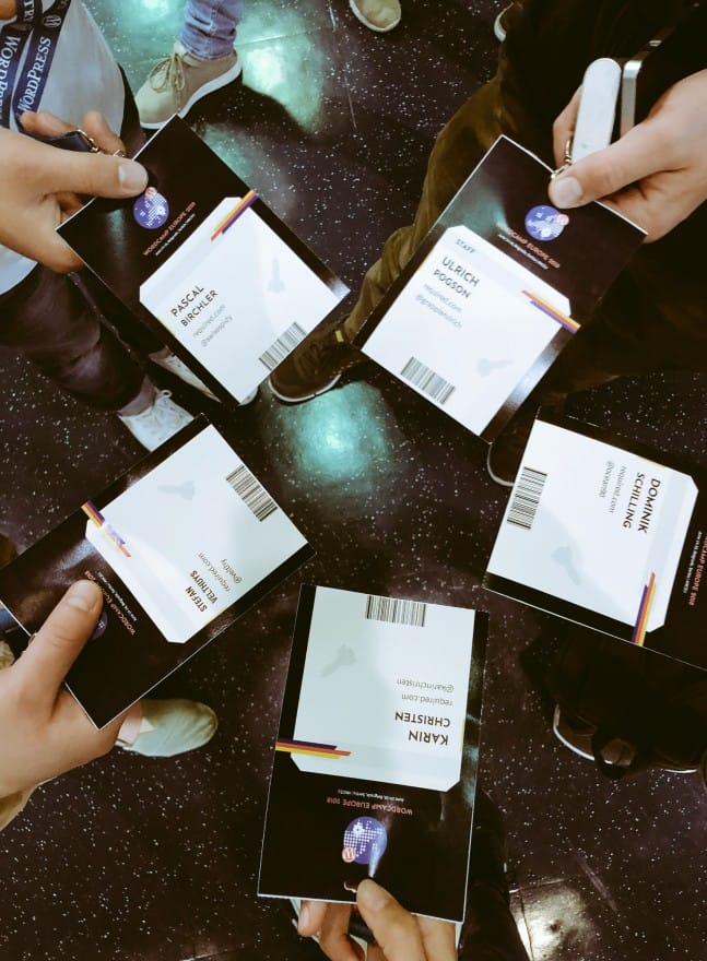 Photo of five different attendee badges at WordCamp Europe, photographed from above.