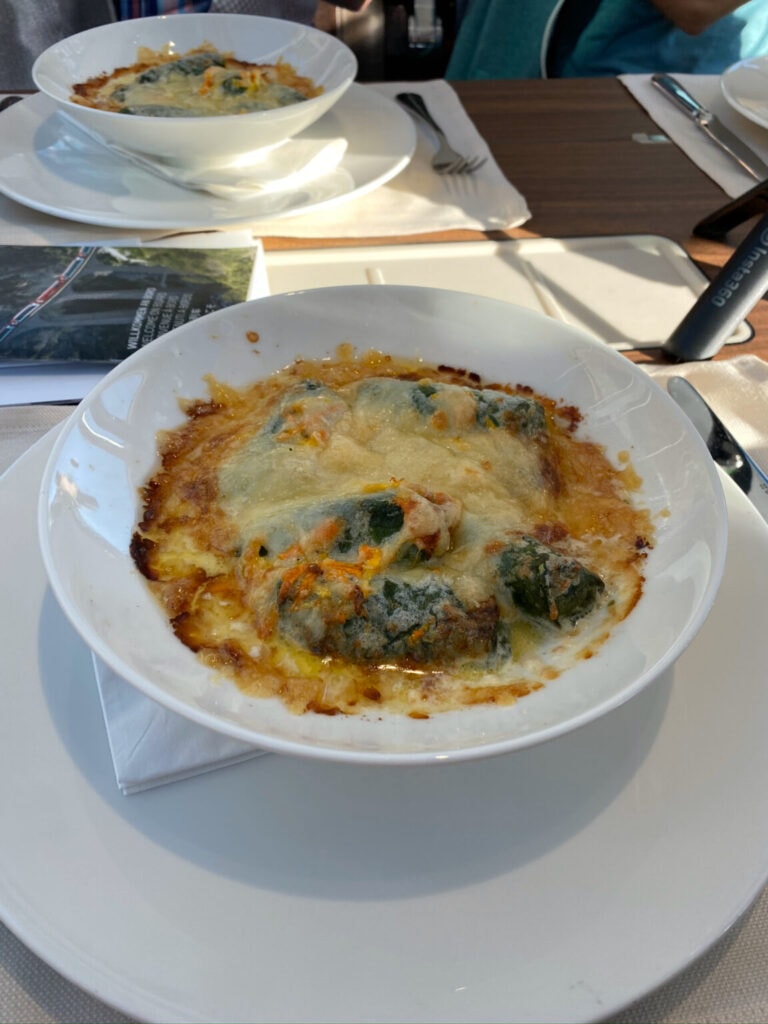 a dish on a plate which is gratinated with cheese