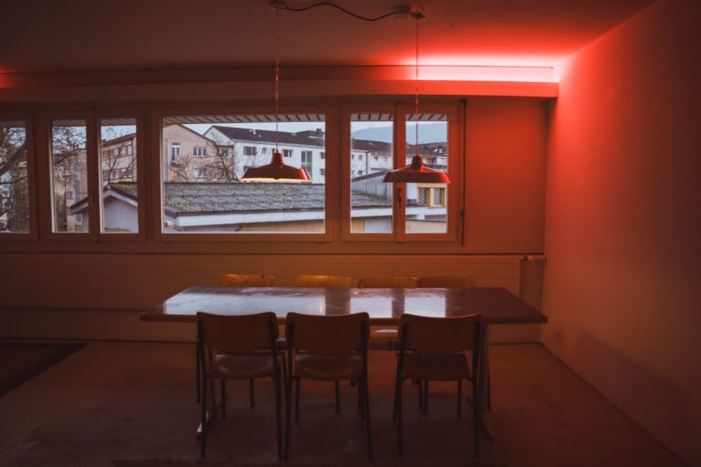 ein mit Möbeln und einem großen Fenster ausgestatteter Raum