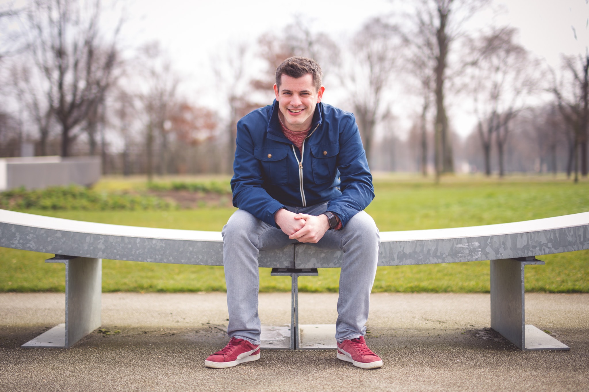 Dominik Schilling, fotografiert in einem Park, sitzend auf einer Bank