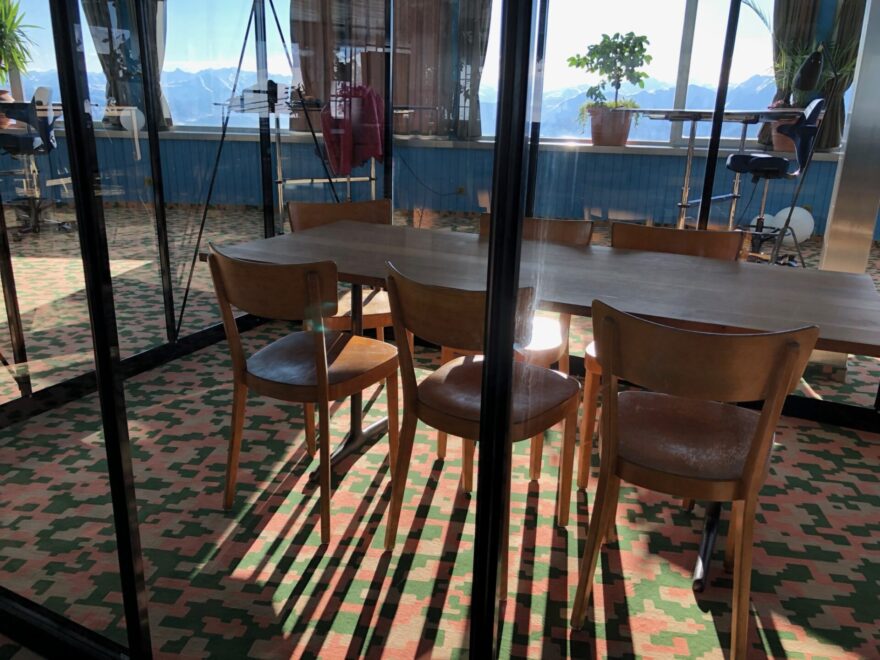 Foto von einem Tisch und Arbeitsstühlen mit sonnigem Hintergrund und Blick auf die Berge