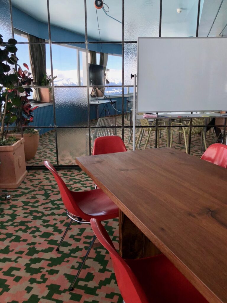 Photo of the meeting room with a long table, chairs and a whiteboard