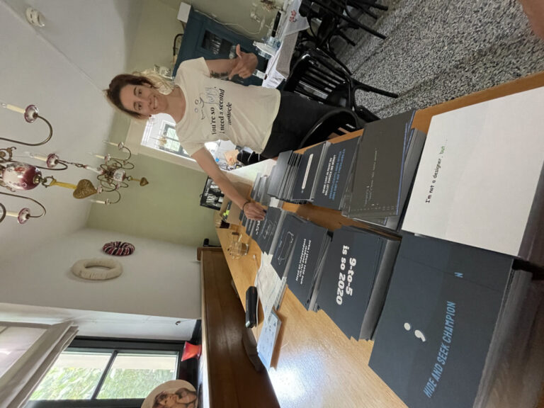 Karin in front of a long stack of postcards