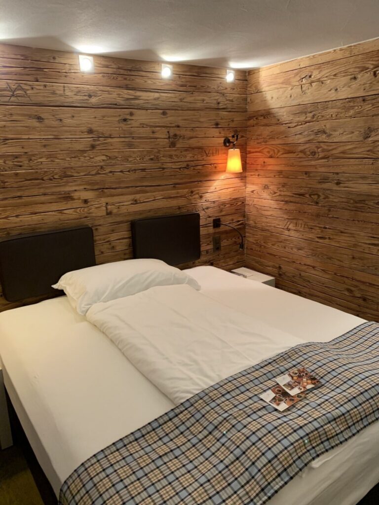 Foto vom Zimmer und Bett mit Holzwänden