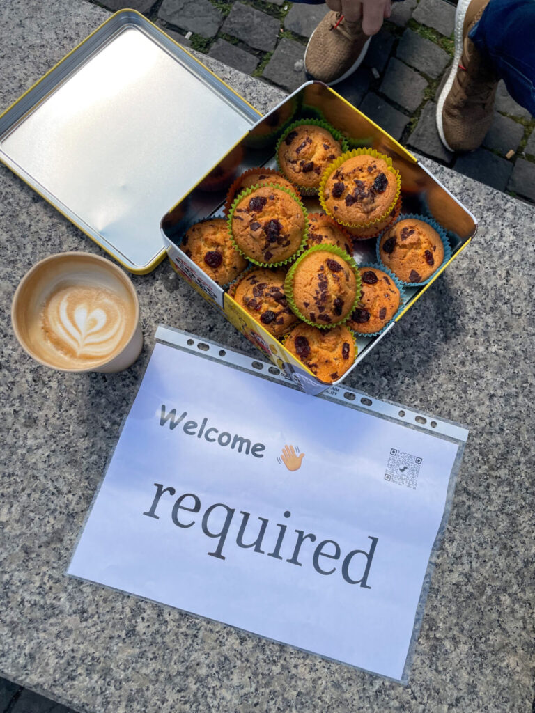 the required sign with coffee and a tin of muffins