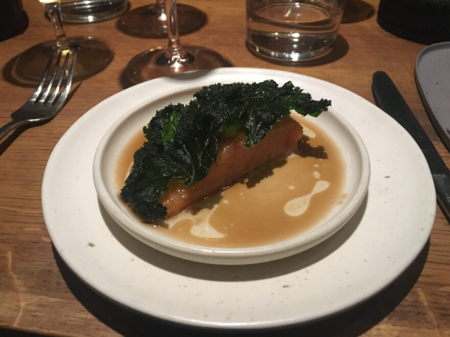 a dish prepared on a plate with a sauce and kale