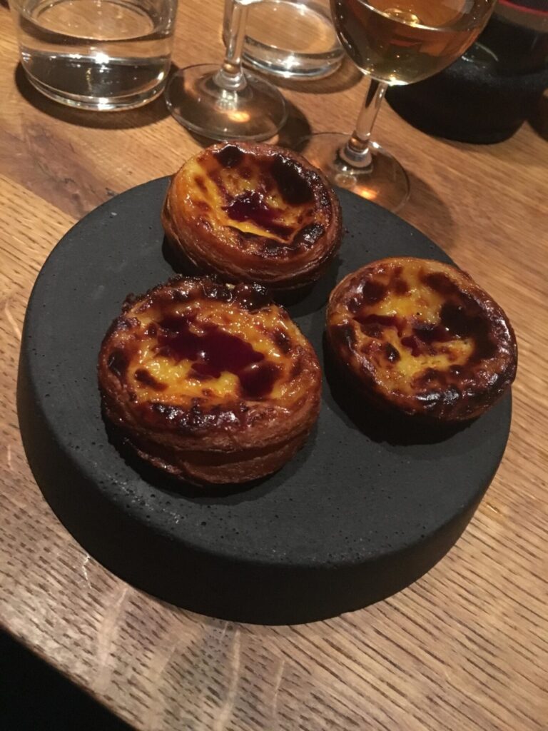 drei Pasteis de nata auf einem Teller hergerichtet