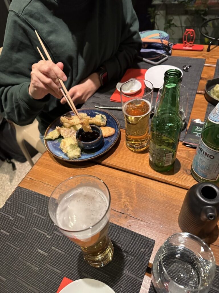 a laid table with lots of drinks and Asian food
