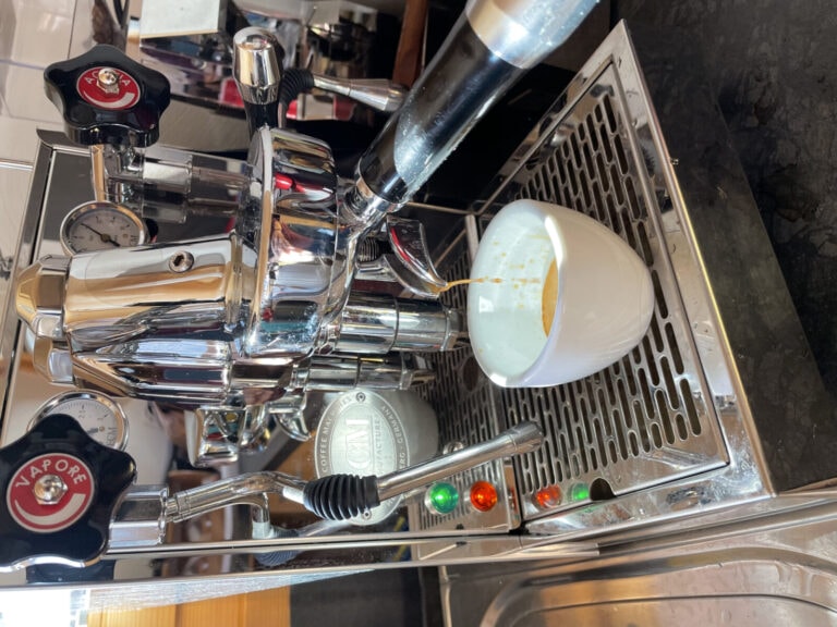 A coffee machine that is currently brewing coffee