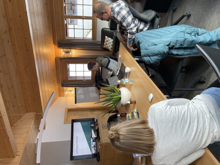 Ulrich, Corina and Velthy sitting at a large table in front of a screen