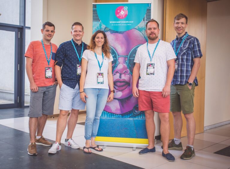 required Team group photo in front of a conference banner