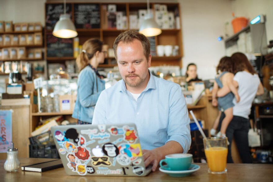 Velthy working on his laptop at a coffee shop.