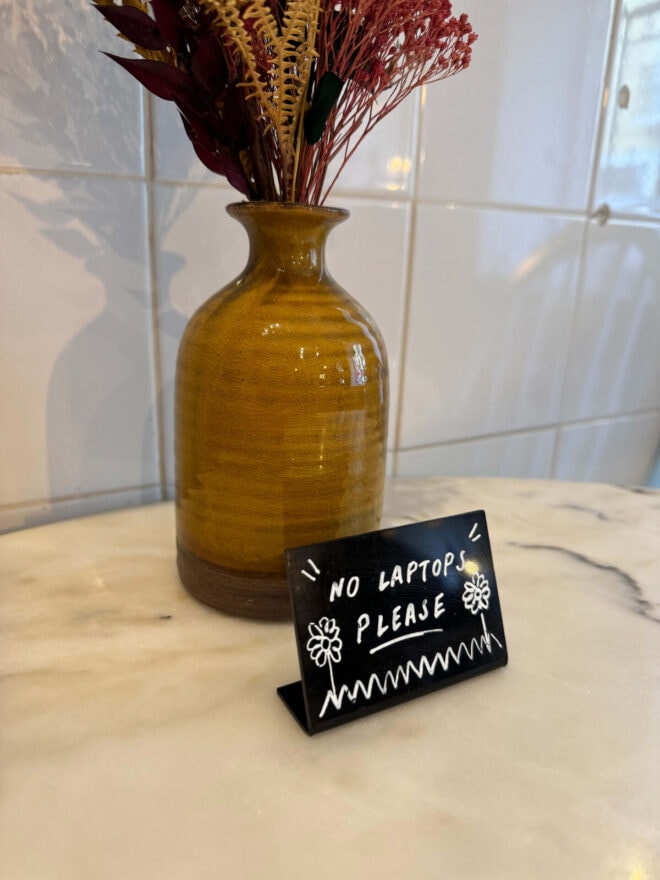 A table with a sign saying that laptops are not allowed.