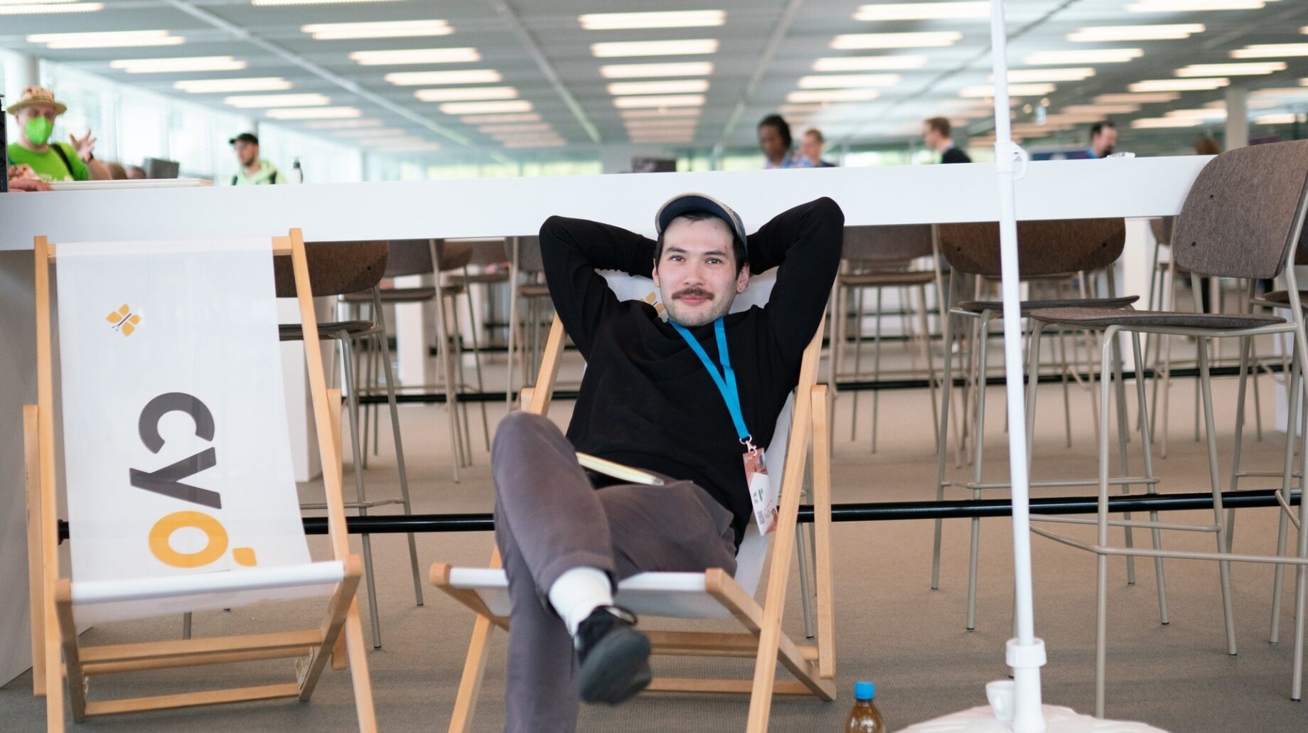 Jeff sits on a deck chair with his hands crossed behind his head.