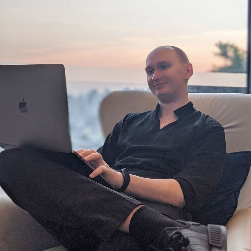 Simon working outside on his laptop in Thailand.