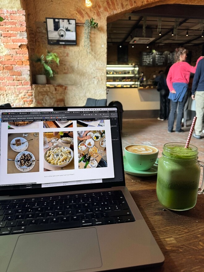Ein Laptop mit unserer Website geöffnet, daneben ein Smoothie und Cafe