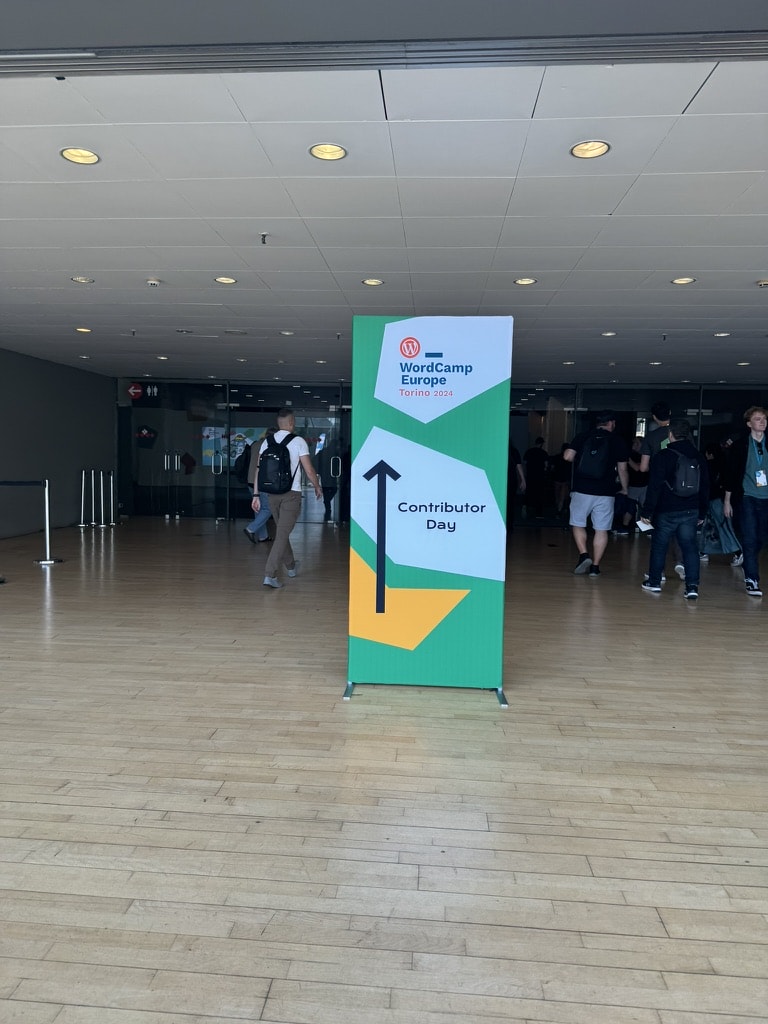 Foto von der Konferenz mit einem Schild für den Conrtibutor Day