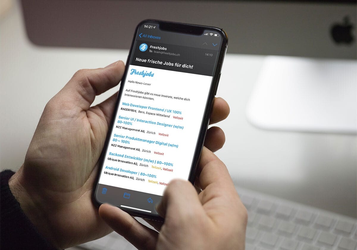 Eine Person hält ein Smartphone in der Hand, auf welchem ein Mail des Freshjobs Job Abos angezeigt wird.