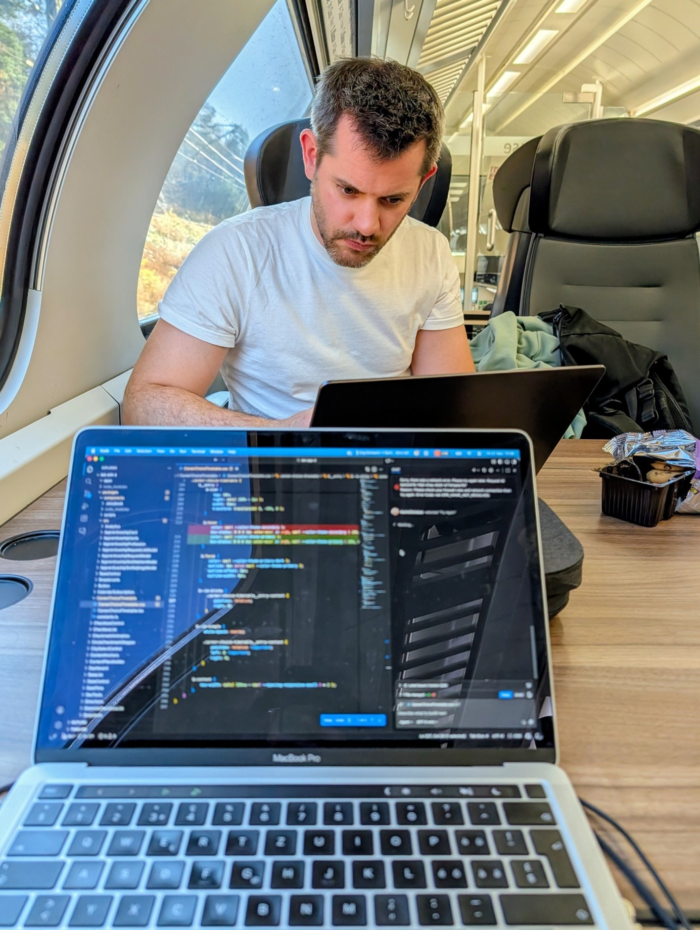 Dominik concentrates on his laptop on the train during the journey to the retreat.