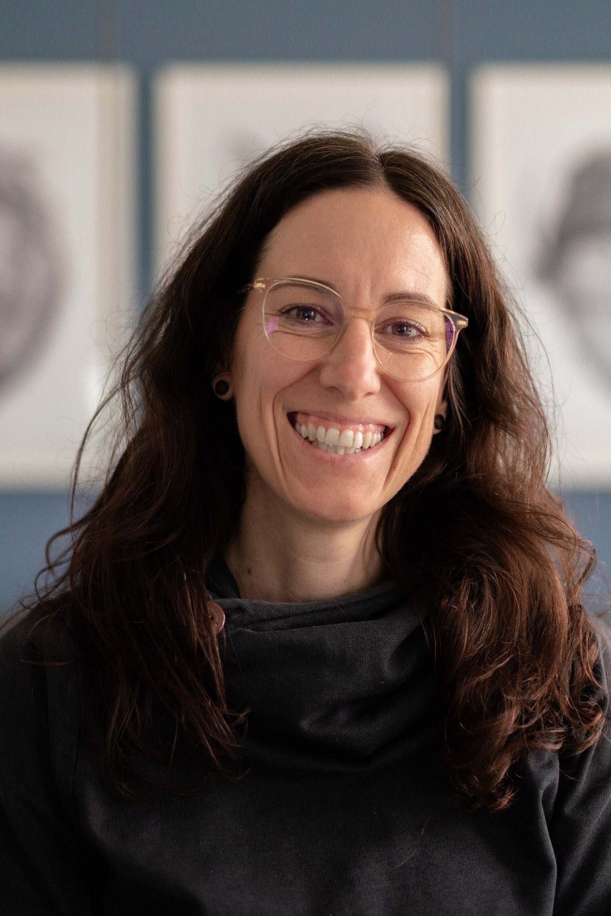 Portrait of Karin with smile in front of calm background. Photographed by Paschi